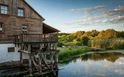 Drewniany młyn nad wodą, otoczony zielenią. Idealne miejsce na weekendowe wypady, szukając fajne miejsca niedaleko Warszawy na weekend.