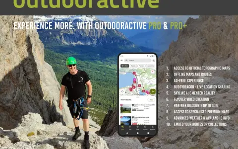 Escursionista sorridente in montagna, con smartphone che mostra l'app outdooractive gratis con mappe e percorsi.