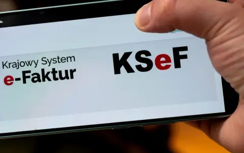 Palec dotyka ekranu telefonu z napisem "Krajowy System e-Faktur KSeF". To część polskiego ładu w finansach.