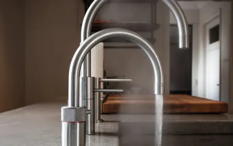 Zwei moderne Küchenarmaturen aus Edelstahl, eine davon mit Dampf. Gute Erfahrungen mit elektrischer Wasserhahn.