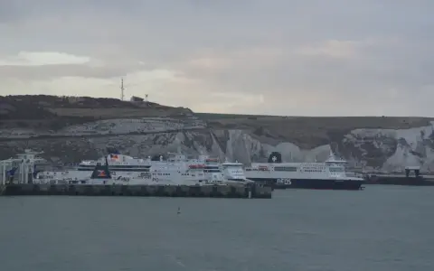 Kilka promów cumuje przy białych klifach. Jeden z nich, z napisem "DFDS", szykuje się do rejsu do Szkocji.