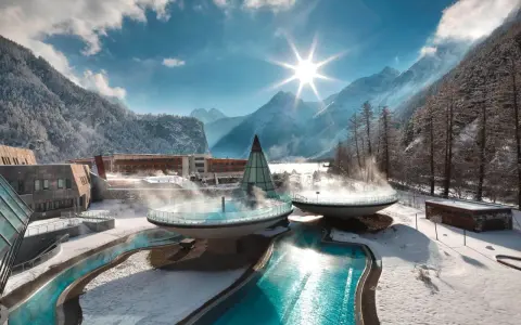 Malownicze termy Austria w zimowej scenerii. Baseny z parującą wodą otoczone ośnieżonymi górami i lasem.