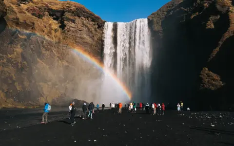 Turyści pod wodospadem Skógafoss na Islandii. Czy do Islandii trzeba mieć paszport? Tak, dla obywateli spoza strefy Schengen.