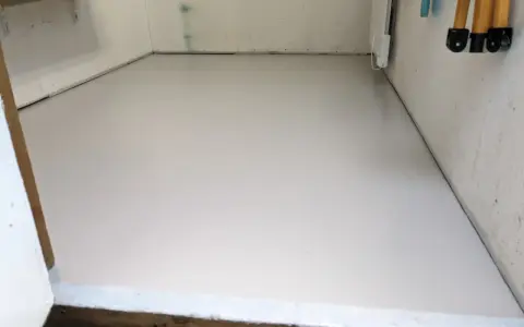 Nymålat betonggolv i ett förråd, redo för nya projekt.