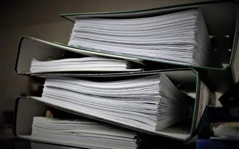 Stosy dokumentów w segregatorach. Może to być materiał do analizy, ale też dowód na to, że popełniono błąd i teraz potrzebny jest czynny żal.