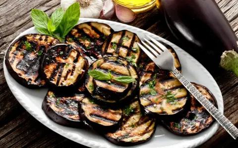 Melanzane grigliate condite con erbe fresche e olio d'oliva. Un contorno saporito e facile da preparare.