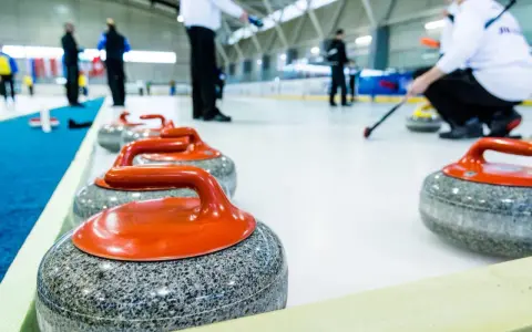 Kamienie do curlingu, każdy ważący ok. 20 kg, czekają na lodzie.