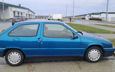 Błękitny Citroen ZX stoi na parkingu.