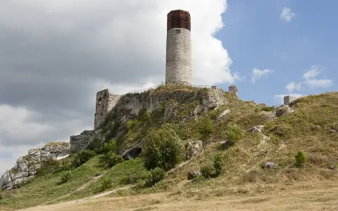 Ruiny zamku na wzgórzu, część Szlaku Orlich Gniazd. Charakterystyczna okrągła wieża i kamienne mury.