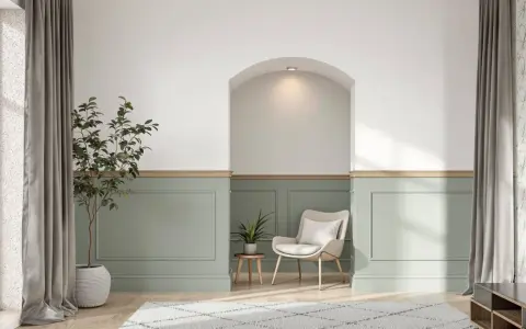 Un salon moderne avec un soubassement de mur peint en vert pâle, orné de moulures. Une niche cintrée au-dessus apporte une touche architecturale.