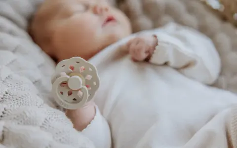 Dziecko śpi ze smoczkiem. Pamiętaj, jak często zmieniać smoczek, by zapewnić higienę i bezpieczeństwo malucha.