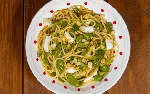 Spaghetti con friggitelli, mozzarella e pangrattato croccante. Un piatto semplice e gustoso, perfetto per un pranzo veloce.