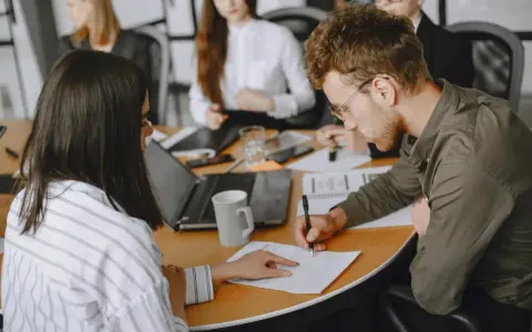 Uomini e donne in riunione, concentrati sul lavoro. Le 40 ore settimanali sono un impegno serio per raggiungere gli obiettivi.