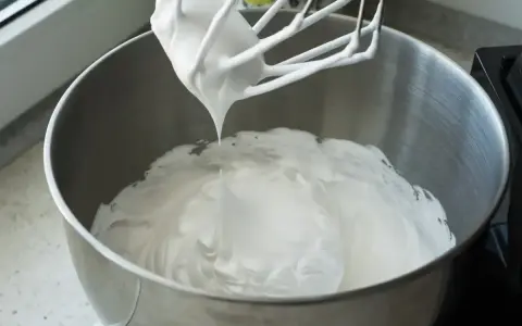Ubita masa z mascarpone i białek, gotowa do przygotowania pysznego ciasta bez pieczenia.