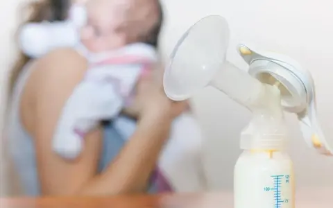 Laktator z butelką mleka, w tle mama z dzieckiem. Zastanawiasz się, ile trwa nawał mleczny?