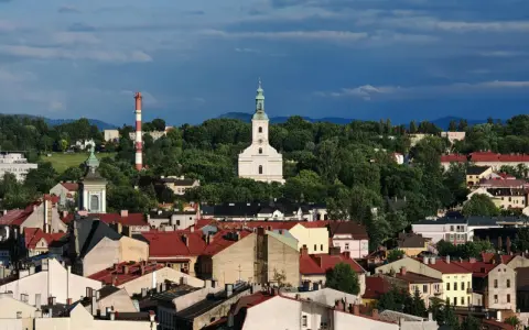 Widok na miasto z kościołem i wieżą, otoczone zielenią. To najstarsze miasto na Śląsku, pełne historii.