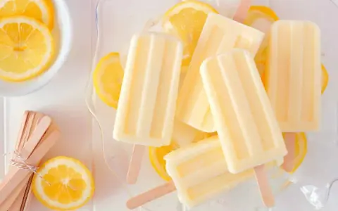 Erfrischendes Zitronen Wassereis selber machen ist einfach! Hier sind cremige Eis am Stiel mit frischen Zitronenscheiben.