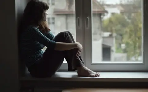Dziewczyna siedzi na parapecie, patrząc przez okno. Czy to melancholia co to? Smutek i zaduma w jej oczach.