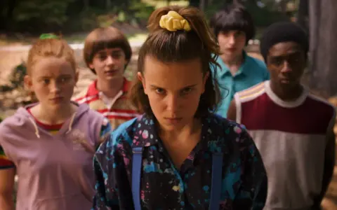 Die Gruppe aus Stranger Things, bereit für ein Abenteuer, während die ikonische Stranger Things Musik im Hintergrund spielt.