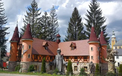 Zamek śląskich legend z wieżyczkami i kamiennymi rzeźbami.