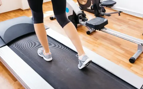 Gambe di donna che cammina su un tapirulan, in allenamento per la gravidanza.