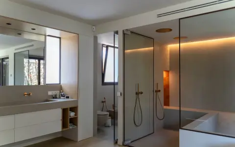 Moderno baño con ventana, ducha de cristal, bañera y lavabo doble.