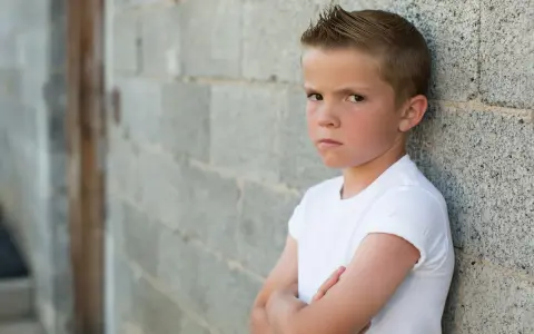 Niño con brazos cruzados y expresión desafiante. La esperanza es que el trastorno negativista desafiante se cura con apoyo.