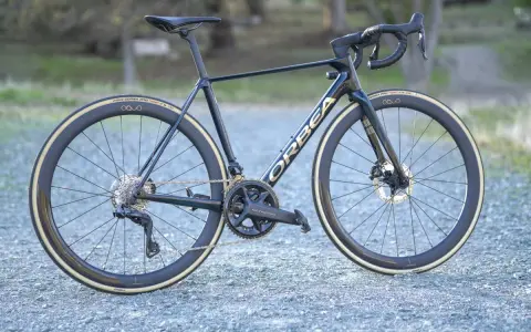 A dark blue Orbea Orca road bike with gold lettering, Ultegra components, and deep-dish wheels. This is a great bike for an Orbea Orca review.