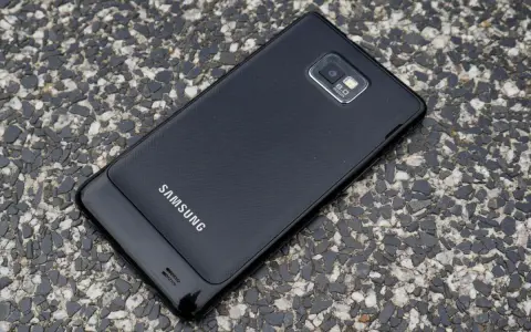 Czarny Samsung Galaxy S2 leży na kamienistej nawierzchni.