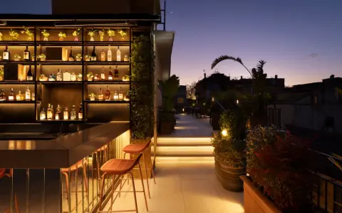 Terrazza panoramica con bar illuminato e sedie, ideale per scoprire le cose da fare a Roma nel weekend.