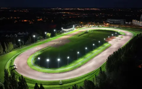 Vue aérienne d'un hippodrome illuminé la nuit, rappelant le nombre d'hippodrome en France.