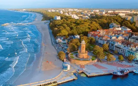 Idealne miejsce, gdzie nad morze. Widok na plażę, molo, latarnię i nadmorskie miasteczko.
