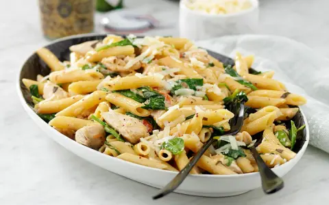 En läcker kycklinggryta med pasta, spenat och riven ost. En perfekt middag!