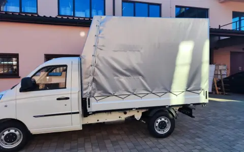 Biały samochód ciężarowy do 2,5 tony z plandeką gotowy do transportu towarów.