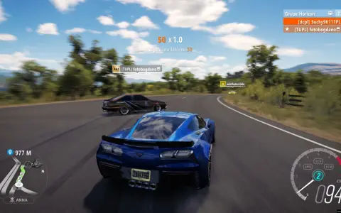 Wyścig w Horizon 3: niebieski Chevrolet Corvette ściga się z innymi autami na krętej drodze.
