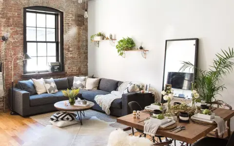 Sofá gris, mesa de centro redonda, mesa de comedor de madera y espejo de cuerpo entero crean un ambiente de **estilo cozy**.