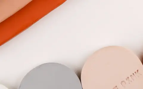 Stavar av lera som inte torkar i grått, rosa och orange, samt runda provbitar märkta "TERRACOTTA" och "ROSE PINK".