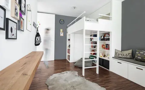 Ein weißes Hochbett mit integrierten Regalen und Stauraum bietet viele Ideen unterm Hochbett für Spielzeug und Bücher. Ein Holzbalken und ein Kuhfell-Teppich ergänzen den Raum.