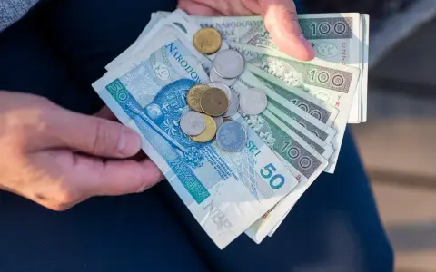 Dłonie trzymają polskie banknoty i monety. Ile razy można dać darowiznę dziecku? Zależy od kwoty i potrzeb.