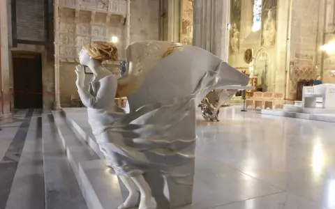 Marmorengel in einer Kathedrale, der betet. Die Skulptur erinnert an einen bibel verse über Hoffnung und Glauben.