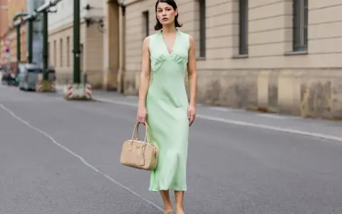 Elegancka zielona sukienka z beżową torebką i brązowymi balerinkami – idealne dodatki do zielonej sukienki na miejski spacer.