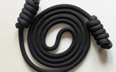 Schwarzes Seil mit Metallenden, kunstvoll zu einer Spirale gewickelt. Der rope flow erzeugt ein faszinierendes Muster.