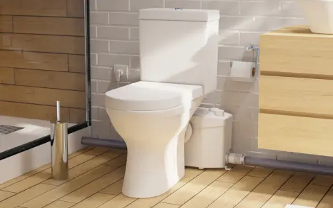 Moderno baño con inodoro triturador, lavabo de madera y ducha. Opiniones positivas sobre su eficiencia.