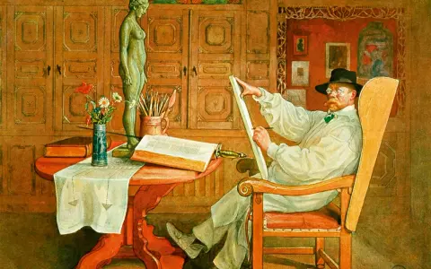 Carl Larsson sitter i en stol och ritar på en duk. Framför honom står en statyett, en bok och en vas med blommor.