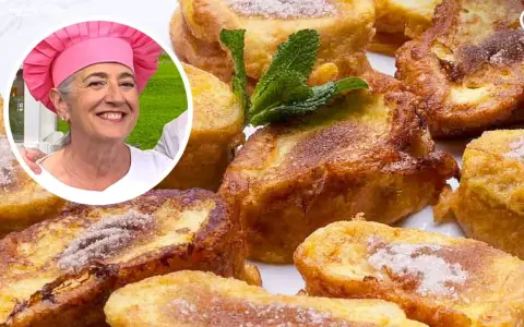 Una mujer sonriente con gorro de chef rosa presenta deliciosas torrijas con pan de molde, espolvoreadas con azúcar y canela.