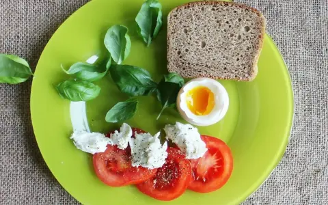 Śniadanie: jajko na miękko, pomidory z mozzarellą, chleb. Idealne, gdy zastanawiasz się, ile gotować jajka na miękko.