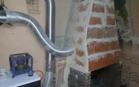 Instalación de tubos flexibles para estufa de leña, conectando a la chimenea de ladrillo.