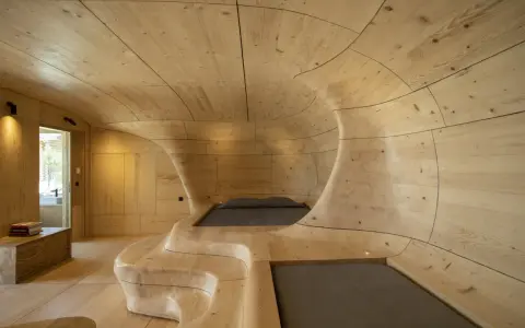 Interior de una casa cueva con paredes y techo de madera curvada, creando un espacio orgánico y acogedor.