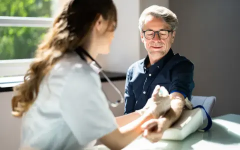 Pielęgniarka pobiera krew do badań. To jedno z wielu badań, jakie może zlecić pielęgniarka, by monitorować stan zdrowia pacjenta.