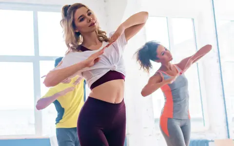 Trzy osoby tańczą w rytm muzyki. To świetny sposób na ćwiczenia, jeśli zastanawiasz się zumba co to.